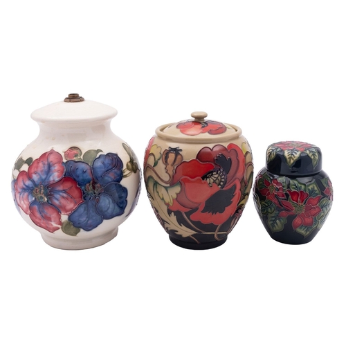 35 - A Moorcroft pottery lamp and two jars and covers, the former in the Clematis pattern on an ivory gro... 