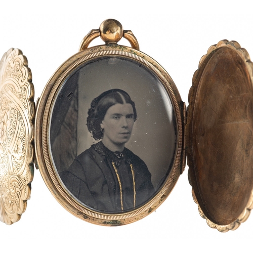 412 - An ornately engraved ambrotype Victorian gilt locket, with floral and foliate engraving to both side... 