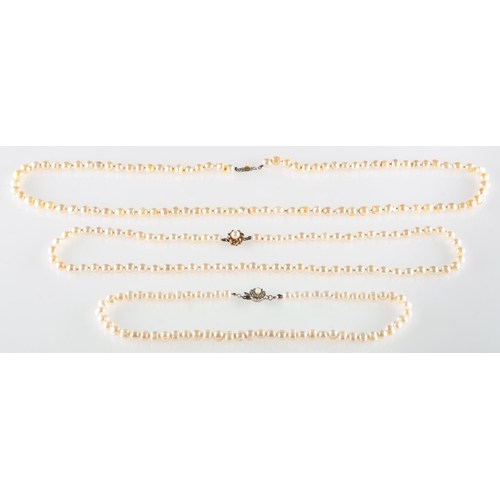 536 - A group of three pearl necklaces, including a cultured pearl necklace to a flowerhead designed clasp... 