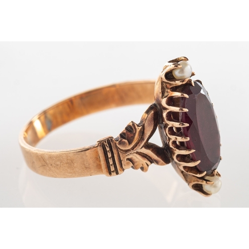 625 - A Victorian garnet and pearl ring, claw set with a marquise-cut garnet, terminating at each end with... 