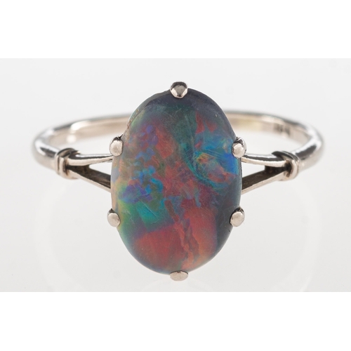 689 - A black opal ring, claw set with a black oval opal cabochon, 'V' split shoulders, opal measures appr... 