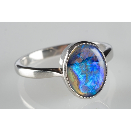 690 - A modern black opal ring, collet set with a black oval opal cabochon, opal measures approx. 10.0mm x... 