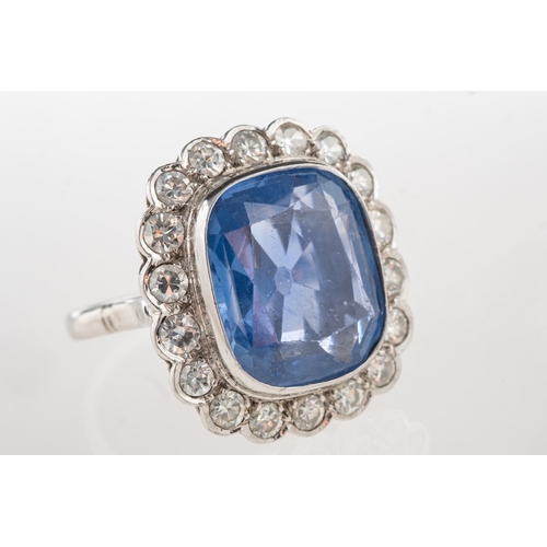 692 - A fine and impressive sapphire and diamond cluster ring, collet set to the centre with a mixed facet... 