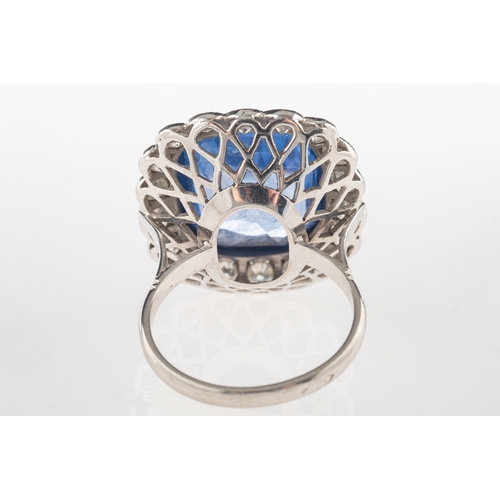 692 - A fine and impressive sapphire and diamond cluster ring, collet set to the centre with a mixed facet... 