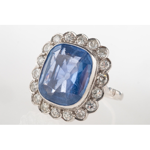 692 - A fine and impressive sapphire and diamond cluster ring, collet set to the centre with a mixed facet... 