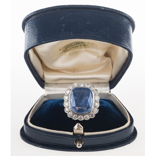 692 - A fine and impressive sapphire and diamond cluster ring, collet set to the centre with a mixed facet... 