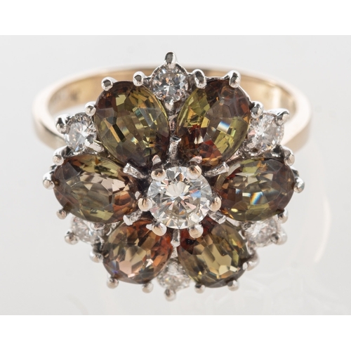 729 - A diamond and andalusite cluster ring, of flowerhead form, claw set with seven brilliant-cut diamond... 