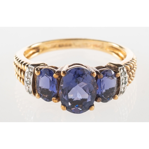 731 - A 9ct gold purple stone and diamond ring, claw set with three oval-cut purple stones, with three sma... 