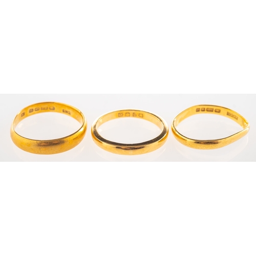 793 - Three 22ct gold bands, including a 22ct gold wedding band, UK hallmark, size M to M1/2, 4.2grams; a ... 