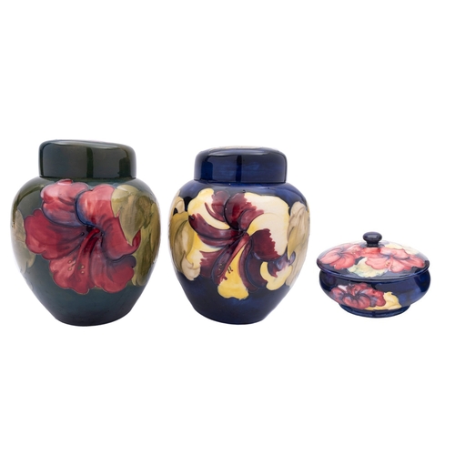 22 - Two Walter Moorcroft pottery jars and covers tube lined in the Hibiscus pattern reserved on a blue a... 