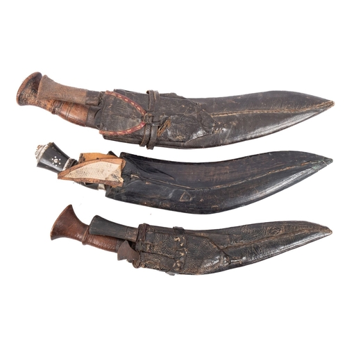 140 - A group of three various kukris  in black leather scabbards (3).