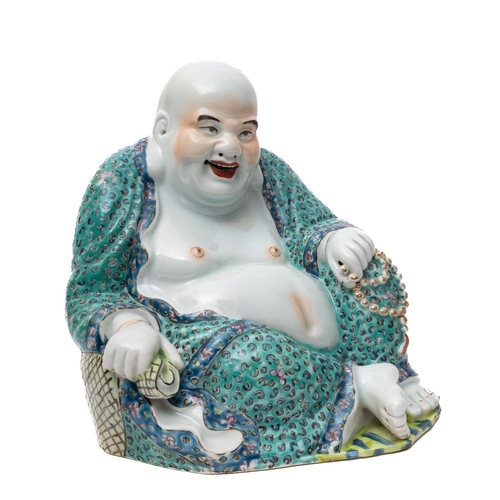 A Chinese porcelain figure of Hotei the portly and jovial God in seated ...
