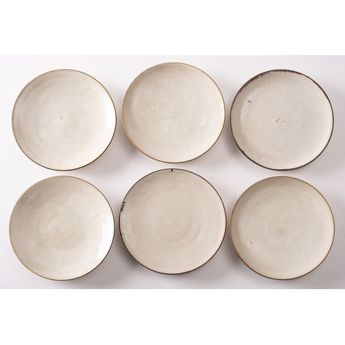 18 - *Dame Lucie Rie DBE [1902-1995] six stone ware saucers with off white glaze and manganese rims, 14cm... 