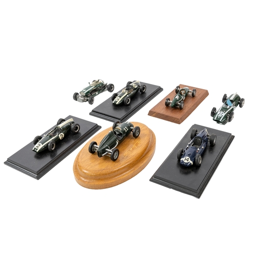 636 - A group of seven built white metal Cooper racing cars, five mounted on display plinths, various make... 