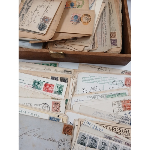 112 - World Postal History. A wooden box full of old covers, postal stationery, and postcards, early to mi... 