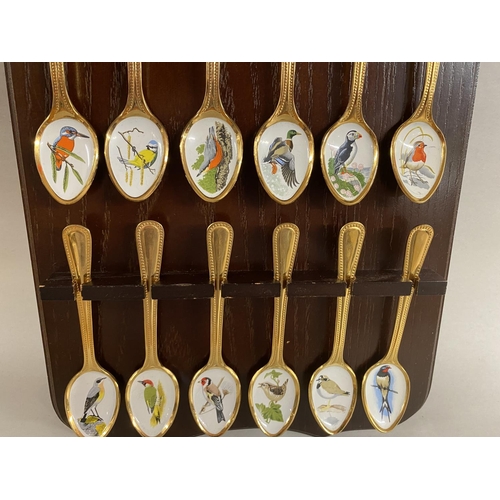 151 - Set of 12, Spink Gold Plated & Enameled 'British Birds' Teaspoons on Wooden Display Stand