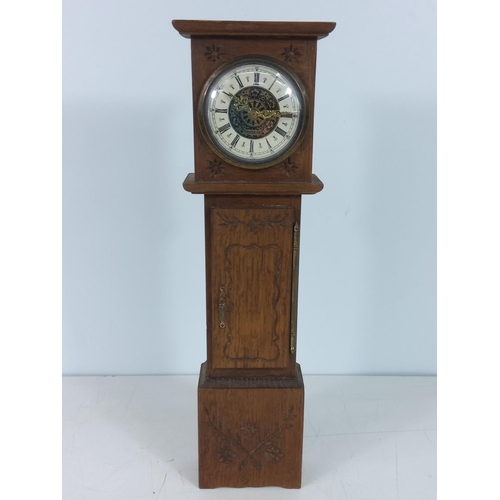 770 - Wood effect miniature long cased clock