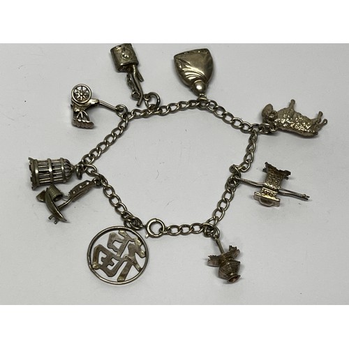 619 - Silver charm bracelet with approx 8 charms - gross 20g