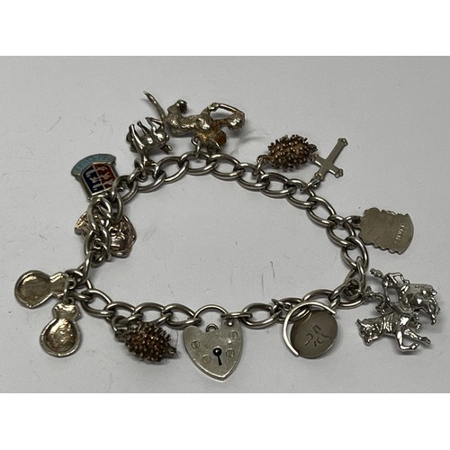 617 - Silver charm bracelet with approx 11 charms - 37.7g gross