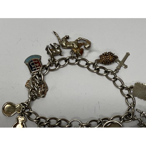 617 - Silver charm bracelet with approx 11 charms - 37.7g gross