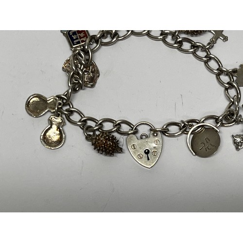 617 - Silver charm bracelet with approx 11 charms - 37.7g gross