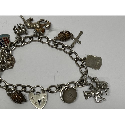 617 - Silver charm bracelet with approx 11 charms - 37.7g gross