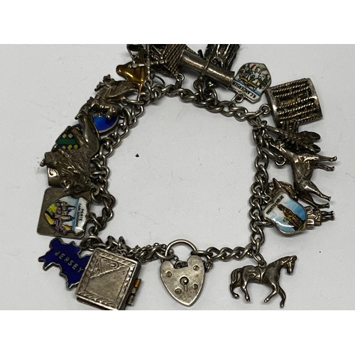 616 - Silver charm bracelet with approx 19 charms 65g