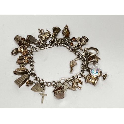 615 - Silver charm bracelet with approx 21 charms - 66.7g gross