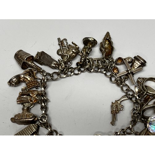 615 - Silver charm bracelet with approx 21 charms - 66.7g gross