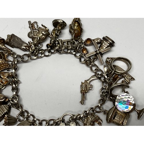 615 - Silver charm bracelet with approx 21 charms - 66.7g gross