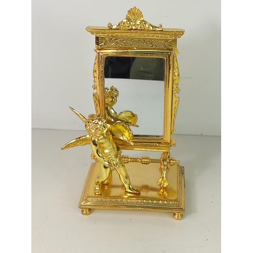 54 - Gilt cast metal cherub mirror, 21cms height