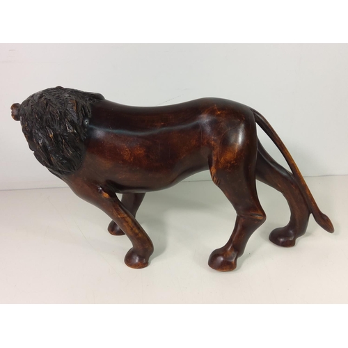 153 - Carved wooden lion figure, height 22cms, length 42cms