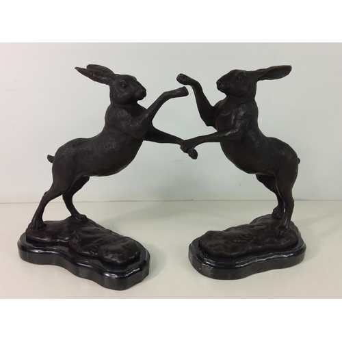 143 - Pair of cast bronze boxing hares on marble bases