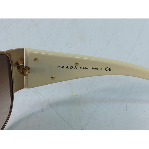 448 - Cased pair of sunglasses with designer label