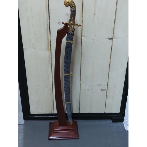 109 - Ornate Franklin Mint sword with sheath on stand, height on stand 105cms