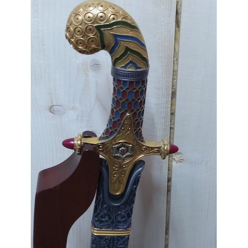 109 - Ornate Franklin Mint sword with sheath on stand, height on stand 105cms