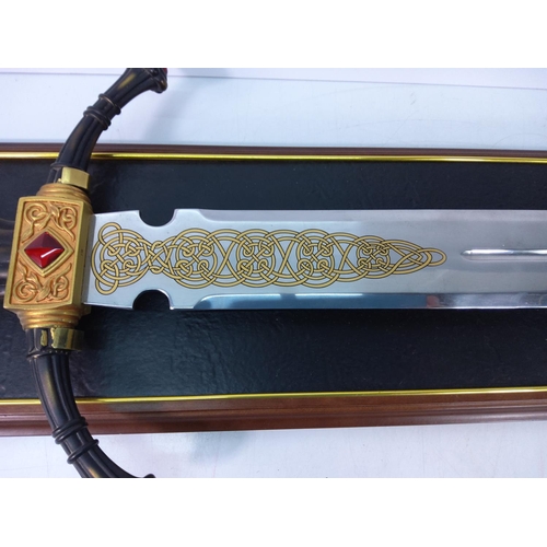 121 - Ornate wooden mounted Franklin Mint sword with Celtic detail to blade, approx 110cms