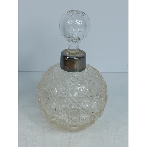 304 - Silver topped cut glass bottle, 15cms in height