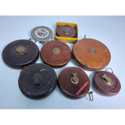 163 - Enamel war lighters, ashtrays and box of leather bound tape measures