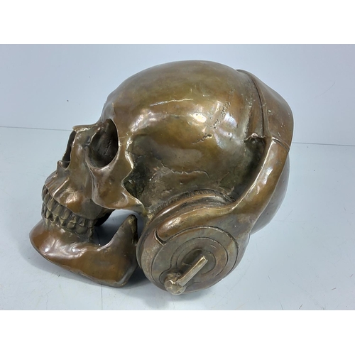 87 - Cast bronze skull with headphones, approx 15cms in height