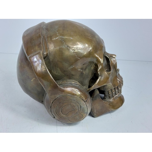 87 - Cast bronze skull with headphones, approx 15cms in height