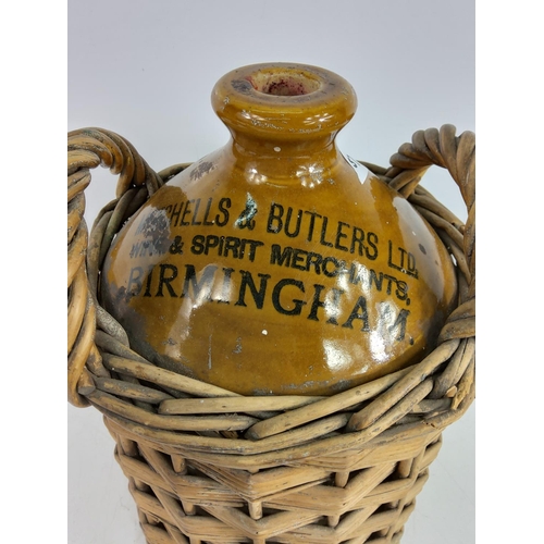 92 - Victorian stoneware beer flagon for Mitchells & Butlers Ltd of Birmingham in a wicker basket