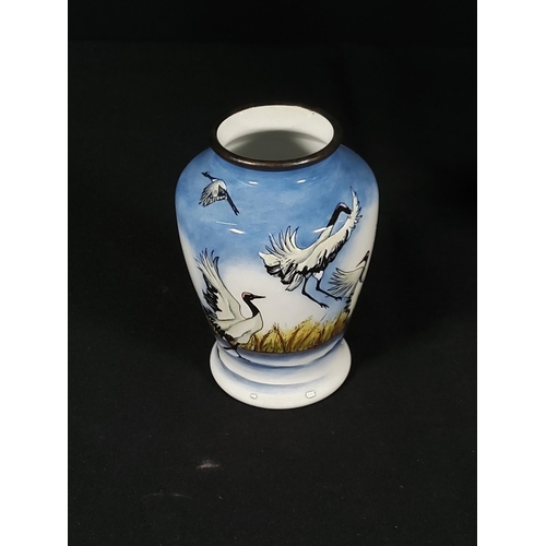 257 - Boxed enamelled Moorcroft vase decorated with  storks, 8cms in height