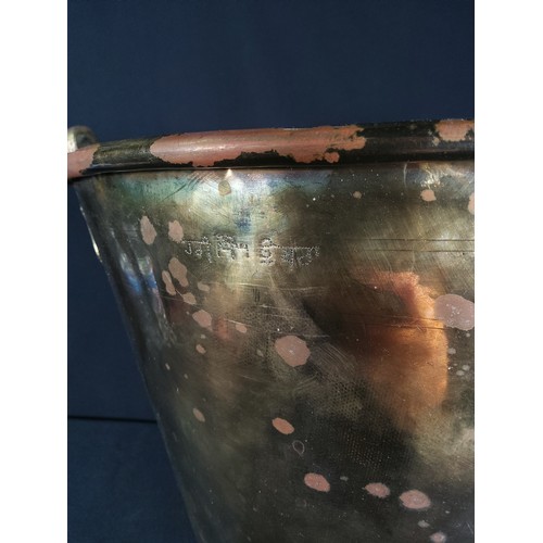 337 - Large antique brass bucket with markings, 32cms in height and 34cms in diameter