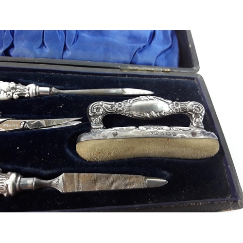 668 - Cased silver 4 piece manicure set and a fork