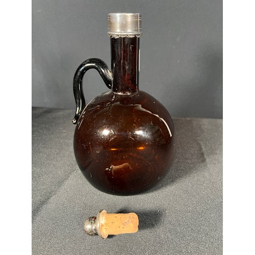 121 - Brown glass bottle with metal rim, 21cm tall