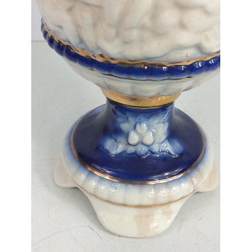 1 - Porcelain urn decorated with cherubs, 28cms in height