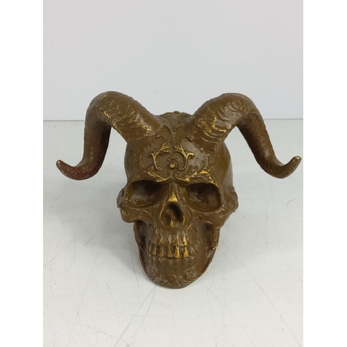 142 - Cast metal skull with horns, 12cms in height