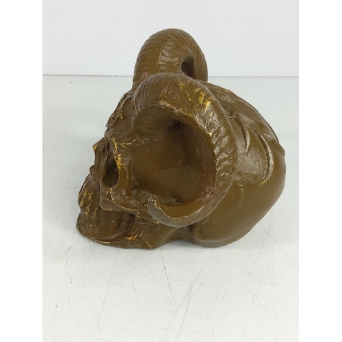 142 - Cast metal skull with horns, 12cms in height