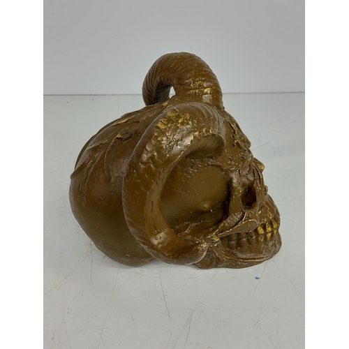 142 - Cast metal skull with horns, 12cms in height